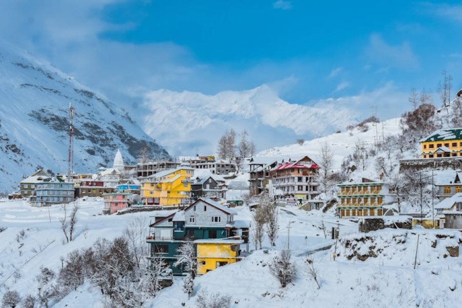 a snow covered mountain with a village in the foreground